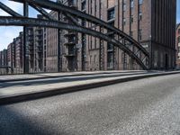 a picture taken of an empty street in a city with tall buildings and a bridge