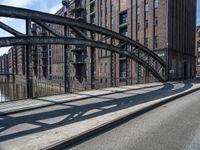 a picture taken of an empty street in a city with tall buildings and a bridge