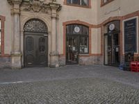 this is an image of a door and a clock on the building's facade