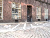 a bicycle is parked at the end of a road in front of a brick building