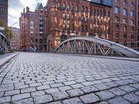 a footbridge that goes across the street of a big building with some windows on top of it