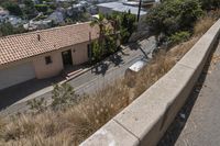 an older street next to a sidewalk on a steep incline next to buildings and some plants