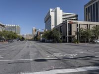 an empty street with several tall buildings and no cars around it, with a sign that says stop