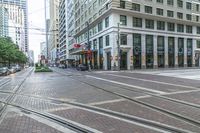 there is a pedestrian in the street next to the building and tracks with no cars