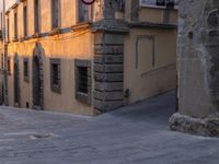 an alley with cobblestone pavement and stone building, and street signs for no walking