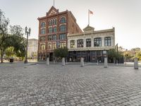 the building is brick and has a clock tower on it's tower next to a red fire hydrant