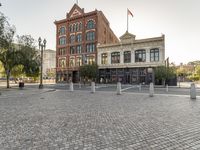 the building is brick and has a clock tower on it's tower next to a red fire hydrant