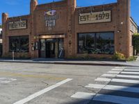 an empty road by an old building with storefront signs in windows and an intersection in front of the store