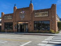 an empty road by an old building with storefront signs in windows and an intersection in front of the store