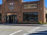 an empty road by an old building with storefront signs in windows and an intersection in front of the store