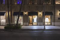 a large windowed building with an awning in front of it on a dark night