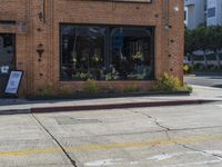 a fire hydrant sitting on the curb in front of a business next to a street