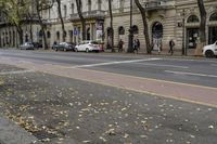 this is a street that is full of cars, bicycles and pedestrians on it and people walking by