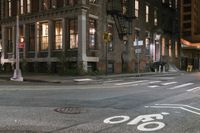 a crosswalk at night near a busy city street with buildings and a no parking sign