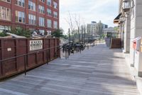 this is a large building with multiple windows and doors, along with an outside bench, two bicycles, and a ramp