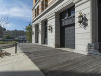 this is a large building with multiple windows and doors, along with an outside bench, two bicycles, and a ramp