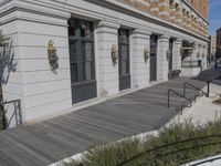 this is a large building with multiple windows and doors, along with an outside bench, two bicycles, and a ramp