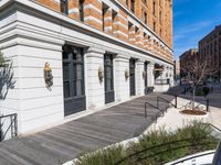 this is a large building with multiple windows and doors, along with an outside bench, two bicycles, and a ramp