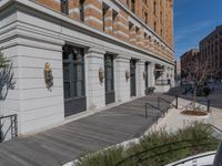 this is a large building with multiple windows and doors, along with an outside bench, two bicycles, and a ramp