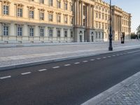 a road near a building with windows and lights on it is shown here in the distance, in europe