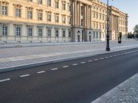 a road near a building with windows and lights on it is shown here in the distance, in europe