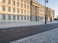 a road near a building with windows and lights on it is shown here in the distance, in europe