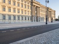 a road near a building with windows and lights on it is shown here in the distance, in europe