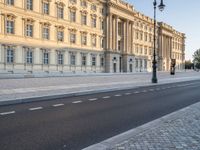 a road near a building with windows and lights on it is shown here in the distance, in europe