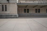 a large building with a sidewalk in front of it and a parking sign that says,