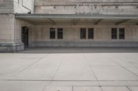 a large building with a sidewalk in front of it and a parking sign that says,