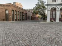 a red brick street that has two building on one side and one in the other