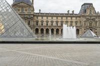 a woman in a hat standing by the entrance to an outdoor area of the louvre