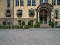 large yellow building with some plants and bushes in front of it for decoration or entertainment