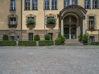 large yellow building with some plants and bushes in front of it for decoration or entertainment