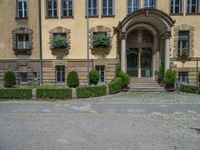 large yellow building with some plants and bushes in front of it for decoration or entertainment