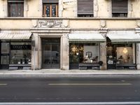 an older store on a city street near some buildings, including a chair, and a table and some chairs