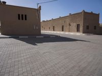 a big brick building with some windows and a lot of bricks on the ground and in front of it