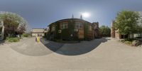 a fisheye lens photo showing houses and a parking lot outside a building at sunny autumn day