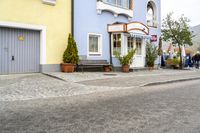 a street scene with a bench and houses on either side of the road where to sit?