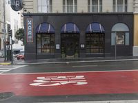 an empty shopping street with store signs painted on the sidewalk in front of it at an intersection