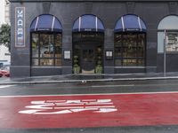 an empty shopping street with store signs painted on the sidewalk in front of it at an intersection