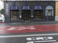 an empty shopping street with store signs painted on the sidewalk in front of it at an intersection