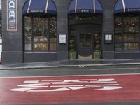 an empty shopping street with store signs painted on the sidewalk in front of it at an intersection