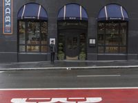 an empty shopping street with store signs painted on the sidewalk in front of it at an intersection