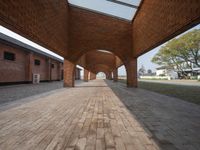 the walkway is lined with brick pillars leading down to a building's entranceway