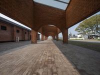 the walkway is lined with brick pillars leading down to a building's entranceway