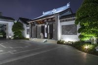 an asian looking home is illuminated by lights on the building's roof and doors