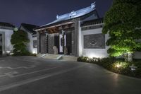 an asian looking home is illuminated by lights on the building's roof and doors