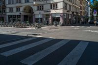 a building sitting next to a crosswalk on the side of street in front of a building with many bicycles parked