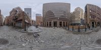 a large street with many buildings around it and a bench in the center of the floor